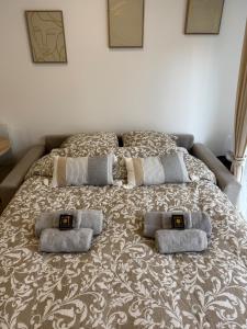 un grand lit avec trois oreillers dessus dans l'établissement Logement Entier Vieux Centre Ozoir-la-Ferrière France, à Ozoir-la-Ferrière