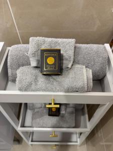 un livre assis sur une étagère au-dessus des serviettes dans l'établissement Logement Entier Vieux Centre Ozoir-la-Ferrière France, à Ozoir-la-Ferrière