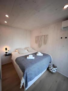 a bedroom with a large bed with two towels on it at Luxury Seaside Villa Privlaka with Jacuzzi and sauna - 10 Gardens - Beach & Relax Croatia in Privlaka