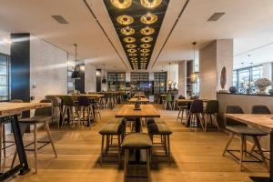 カンプ・リントフォルトにあるWellings Parkhotelの木製テーブルと椅子が備わるレストラン