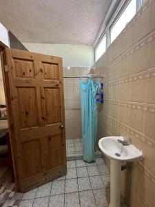 a bathroom with a sink and a wooden door at Chalet brisas del mar in Chiquimulilla +60 photos