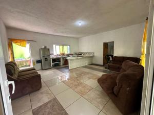 a living room with couches and a kitchen at Chalet brisas del mar in Chiquimulilla