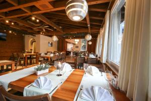 a dining room with a table with white tablecloths and chairs at Hotel Grüsch in Grüsch