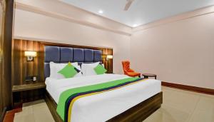 范兰德凡Hotel Light House Urban Silverkey -Free unlimited 5g internet, in house parking- Fully AC - Near Prem Mandir的一间卧室配有一张大床和一张橙色椅子