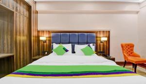 范兰德凡Hotel Light House Urban Silverkey -Free unlimited 5g internet, in house parking- Fully AC - Near Prem Mandir的带一张大床和一把椅子的卧室