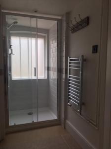 a shower in a bathroom with a glass door at Luxury Large Five Bedroom Family House Sleeps 10 in Milton Abbas