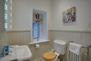 a bathroom with a toilet and a sink and a window at Luxury Large Five Bedroom Family House Sleeps 10 in Milton Abbas +42 photos