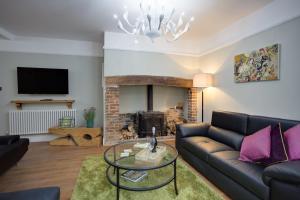 a living room with a couch and a fireplace at Luxury Large Five Bedroom Family House Sleeps 10 in Milton Abbas