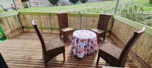 a table and four chairs on a wooden deck at Chalets dans le Luberon in Viens