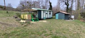 a small shed with a green staircase in a field at Chalets dans le Luberon in Viens