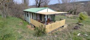 a small house with a green roof on a field at Chalets dans le Luberon in Viens