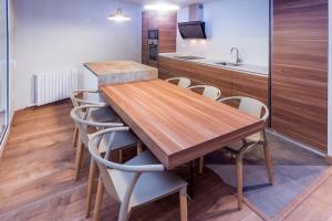 cocina con mesa de madera y sillas en Mònica Mar Apartments, en Cambrils