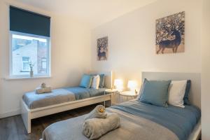 a bedroom with two beds and a window at 4 Bedrooms-4 Bathrooms House in Barrow