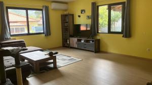 a living room with yellow walls and a table at Casa Azul in São Vicente