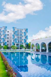 a large swimming pool in front of a building at Santorini 2BR Resort Apt - Negombo Beach & Airport in Negombo