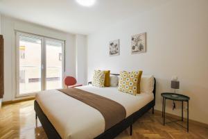 a bedroom with a large bed and a window at Dobo Getafe Uruguay in Getafe