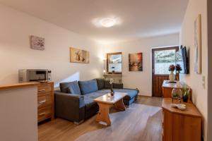 Una sala de estar con un sofá azul y una mesa. en Bergschlössl Whg 3, en Oberaudorf