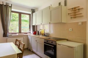 a kitchen with white cabinets and a table and a window at Honeyinn Domek mały in Kamianna