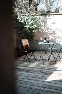 a table with two chairs and a bottle of wine at LA CABANE AFFRANCHIE in Moussy