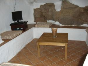 a living room with a table and a tv at CR La Cueva CR-CC-00114 in Casas del Castañar