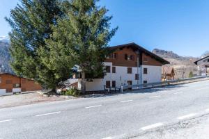 a tree on the side of a road next to a house at Monte Pelmo in Alleghe
