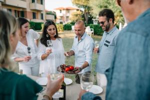 a group of people standing around a table with a plate of food at Villaggio Mietta in Castiglioncello