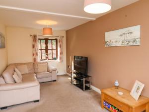 a living room with a couch and a tv at No 18 Riverside Walk Kingfisher in Whitby