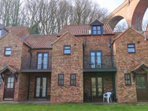 a large brick building with a balcony on it at No 18 Riverside Walk Kingfisher in Whitby