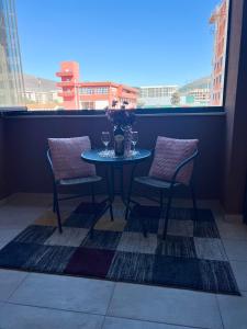 a table and chairs on a balcony with a window at Dora Apartman in Trebinje
