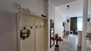a white hallway with a door with flowers on it at Jad Studio Mamaia Nord in Mamaia Nord