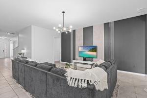 a living room with a large couch and a tv at SUPER JUMBO - 12BD 12BAs SLEEPs 34 - w AMENITIEs in Kissimmee