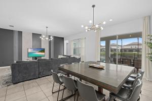 a dining room with a large table and chairs at SUPER JUMBO - 12BD 12BAs SLEEPs 34 - w AMENITIEs in Kissimmee