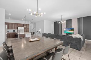 a dining room and kitchen with a table and chairs at SUPER JUMBO - 12BD 12BAs SLEEPs 34 - w AMENITIEs in Kissimmee