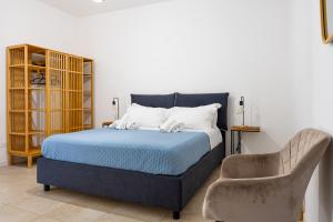 a bedroom with a blue bed and a chair at Il Giardino del Tempio in Agrigento +93 photos