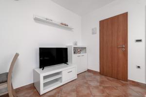 a living room with a flat screen tv on a white wall at Apartments Manuela in Pula