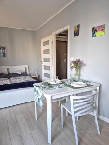 a white table and chair in a room with a bed at Elegant & Cosy in Wrocław