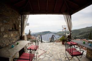 a patio with chairs and a view of the mountains at TERPOU StoneHouse and Suites "StoneHouse" in Áyios Vlásios