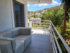 a couch on a balcony with a view of a city at El Mar, Pool House with 3 BDR, 7 min from beach in Saronida