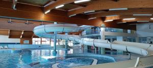 an indoor swimming pool with a water slide at Apartmán C409 v areálu Wellness hotelu Frymburk in Frymburk