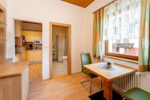 kuchnia i salon z drewnianym stołem i krzesłami w obiekcie Gästehaus Nemast w mieście Weissensee