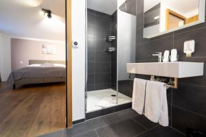 a bathroom with a sink and a shower at La Tgoma - Hotel & Restaurant in Lenz +85 photos