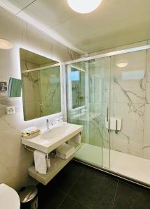a bathroom with a sink and a shower at Best Western Hotel Bellevue au Lac in Lugano