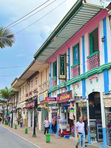 a group of people walking down a street with buildings at Encanto 3 in Santa Rosa de Cabal