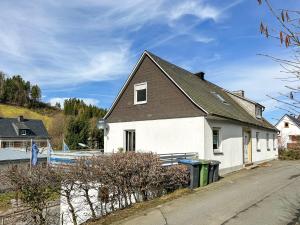 ein weißes Haus mit einem schwarzen Dach in der Unterkunft Silbach Panorama Lodge in Winterberg