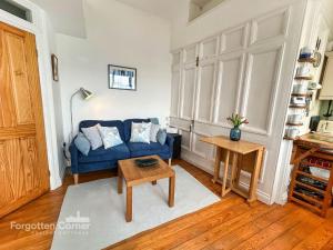 a living room with a blue couch and a table at The Wash House in Torpoint
