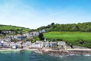 a group of houses on a hill next to the water at The Wash House in Torpoint