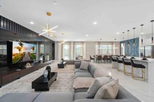 a living room with a couch and a tv in it at SUPER FANCY- 15BDR 17BAs HUGE 7 000SQFT HOME in Kissimmee
