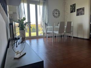 a dining room with a table and white chairs at MaMà - Ma Maison d'Hotes in Vigliano Biellese