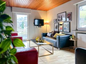 ein Wohnzimmer mit Sofa und Tisch in der Unterkunft Silbach Panorama Lodge in Winterberg