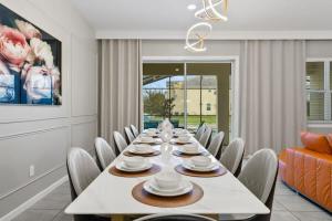 a long dining room with a long table and chairs at SUPER LARGE - 12BD 12BAs - MANY ENSUITEs SLEEPs 30 in Kissimmee